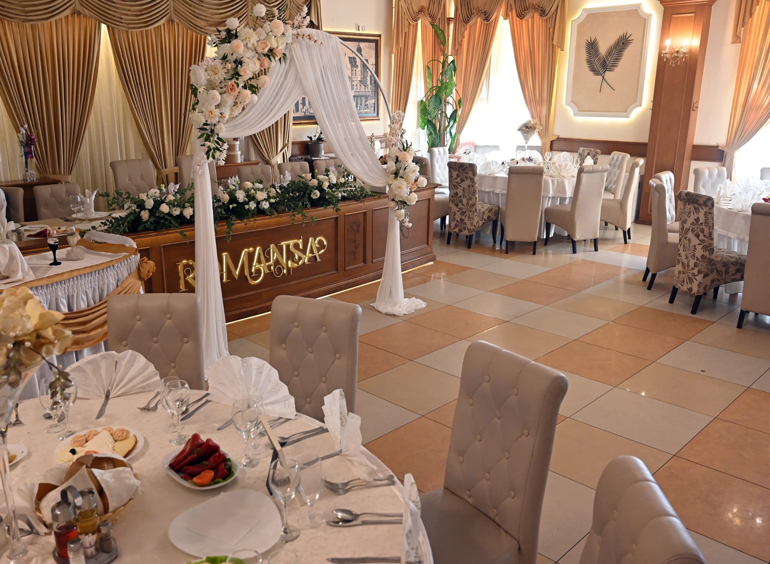 Enterijer sale restorana Romansa sa svečanim cvetnim dekorom